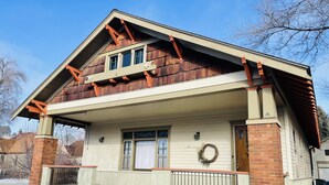 A two-story house with a gabled roof, a front porch, and a brick foundation. - Vintage Gem in the Heart of Sheridan (Sheridan)