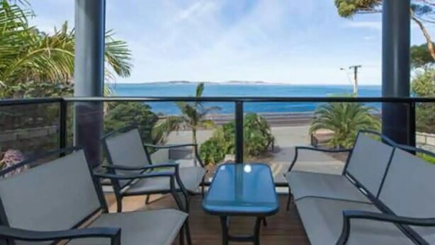 Un balcón con vistas al océano, que incluye una mesa y sillas.