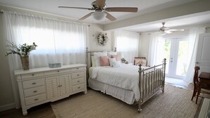 A bedroom with a bed, dresser, and a ceiling fan. - Beautiful waterfront pool home 5 minutes from downtown St Pete! (St. Petersburg)