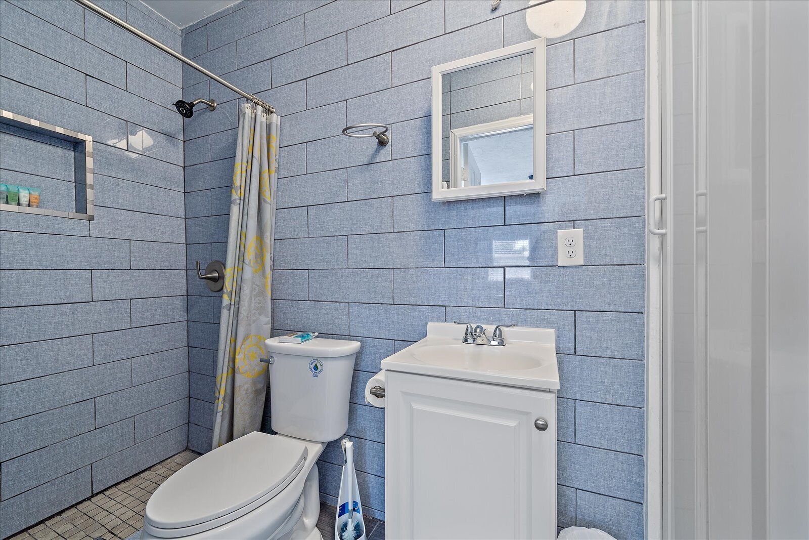 A bathroom with a toilet, sink, and shower area.