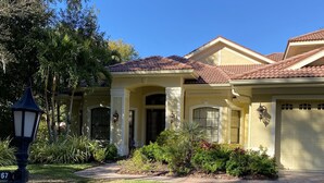 A residential house with a tiled roof, a well-maintained lawn, and a street lamp. - Entire private house VR24-00064  (Sarasota)