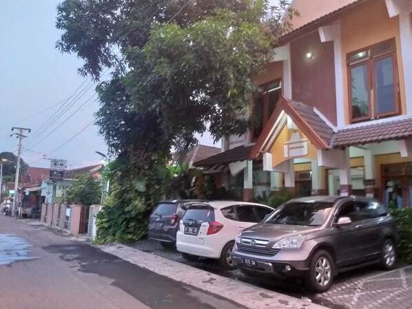 A residential street with parked cars and houses.