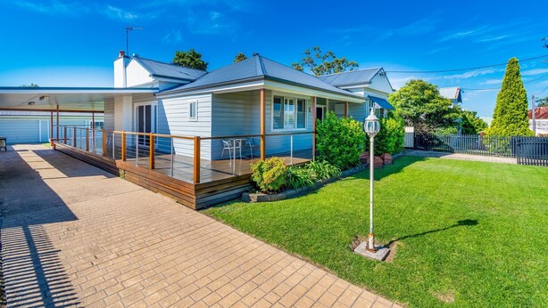 A single-story house with a covered porch, a small deck, and a well-maintained lawn. - Very comfortable, spacious home. (Cessnock)
