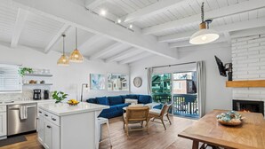 Una cocina moderna con armarios blancos, una isla central e iluminación colgante.