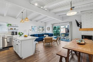 Enjoy a spacious living area with a sofa and dining table for four, a fully equipped kitchen, and a balcony with city views.