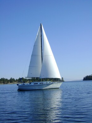 A sailboat on calm waters with a clear sky.