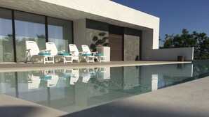 A modern pool area with white lounge chairs and a clear pool. - Very beautiful modern 2-Bed Apartment in Javea (Javea)