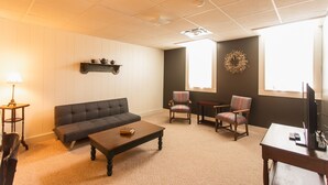 A living room with a sofa, two armchairs, a coffee table, a TV, and a fireplace. - Sleeps 4 Fully Equipped Apartment Near Golf Courses (Corry)