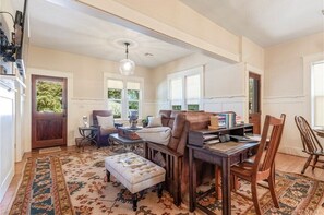 Relax in this inviting living room with a comfortable sofa, leather ottoman, and a wooden coffee table.