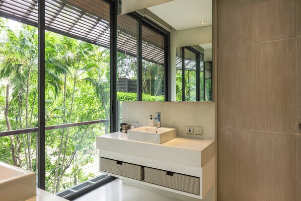 Une salle de bain moderne avec une grande fenêtre, un lavabo blanc et un miroir.