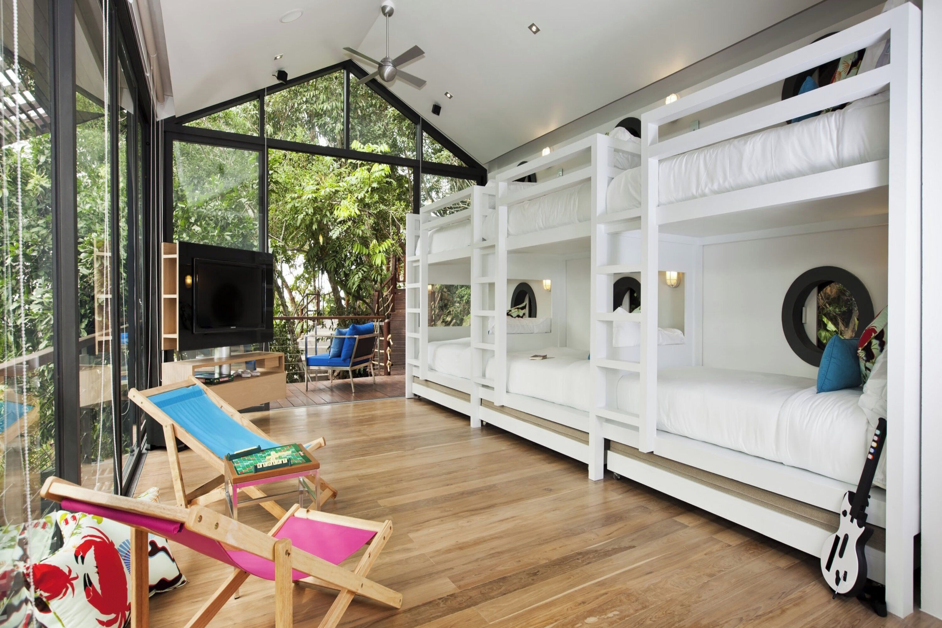 A modern interior with bunk beds, a TV, and a pool table.