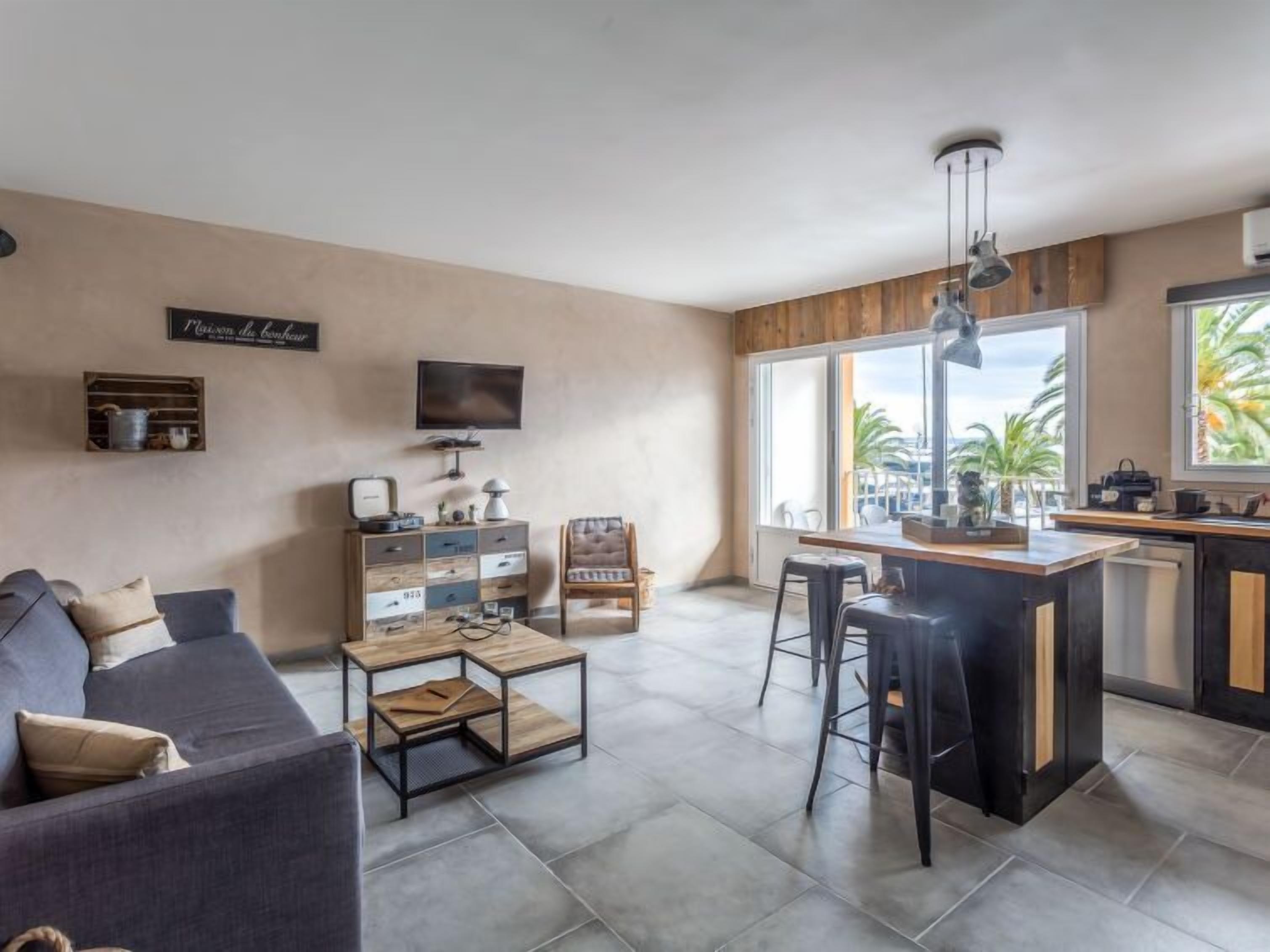 Een moderne woonkamer met een bank, een salontafel, een televisie en een houten kast.