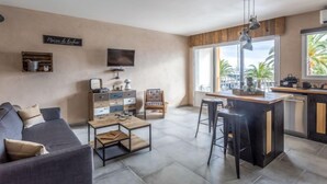 Una sala de estar moderna con un sofá, una mesa de centro, un televisor y un mueble de madera.