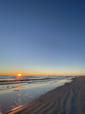 A beach with a sunset, calm waves, and a clear sky. - Discover Seminole charm near John’s Pass (Seminole)