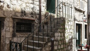 A stone building with a staircase leading to a second floor. - Apartment Ikana (Dubrovnik)
