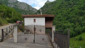 Une propriétéClose-up of a white building with a paved driveway and a mountainous backdrop.