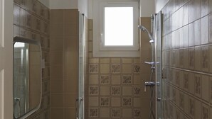 A small bathroom with a shower, a sink, and a mirror. - T3 rue Lamalgue-Mourillon Plages-Toulon (Toulon)