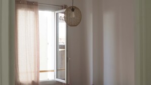 A bedroom with a bed, a window with curtains, a hanging light fixture, and a bedside table. - T3 rue Lamalgue-Mourillon Plages-Toulon (Toulon)
