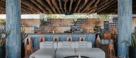 A bar area with a counter, seating, and a decorative wall.