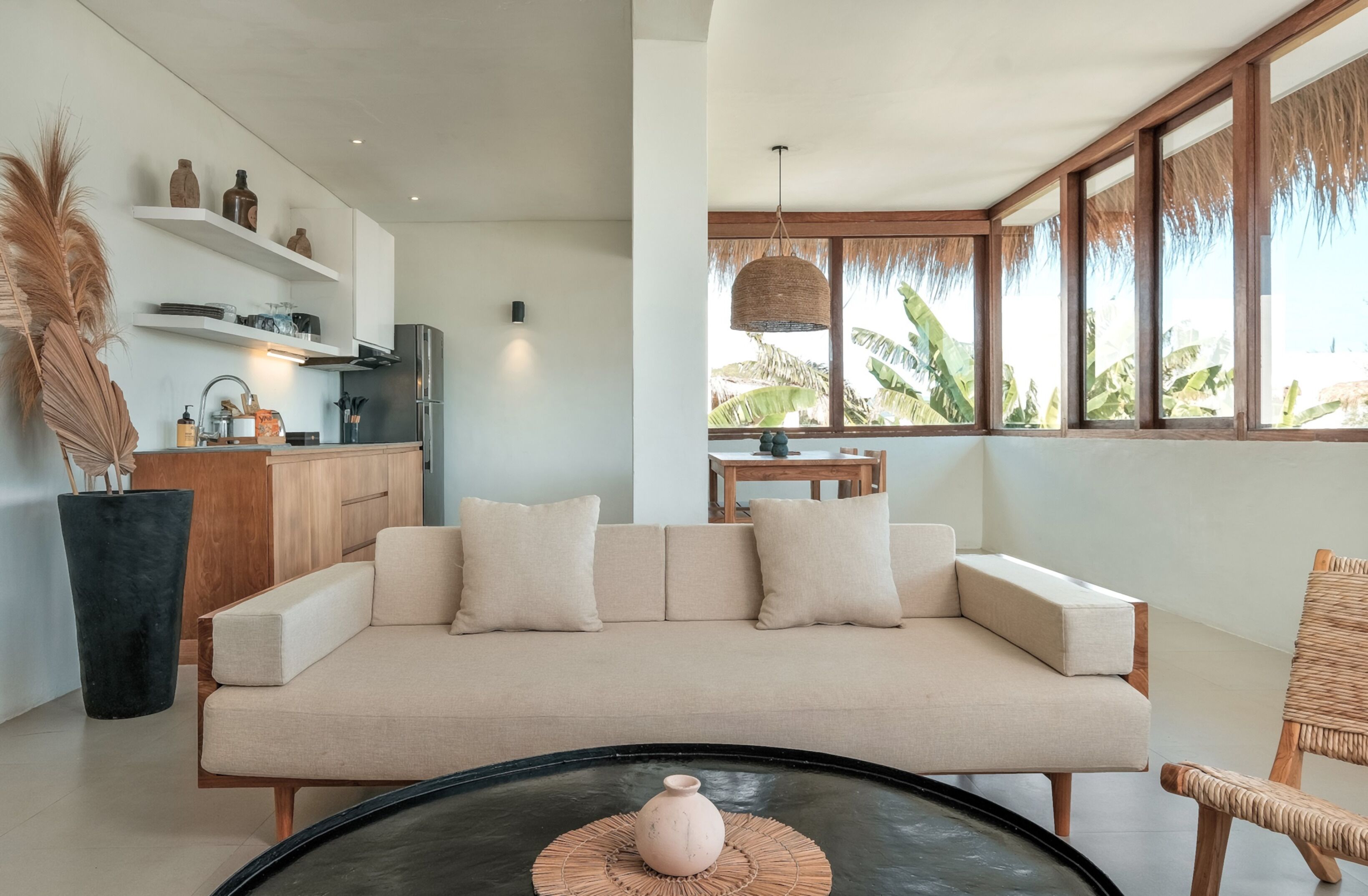Una sala de estar moderna con un sofá, una mesa de centro y vistas al exterior.