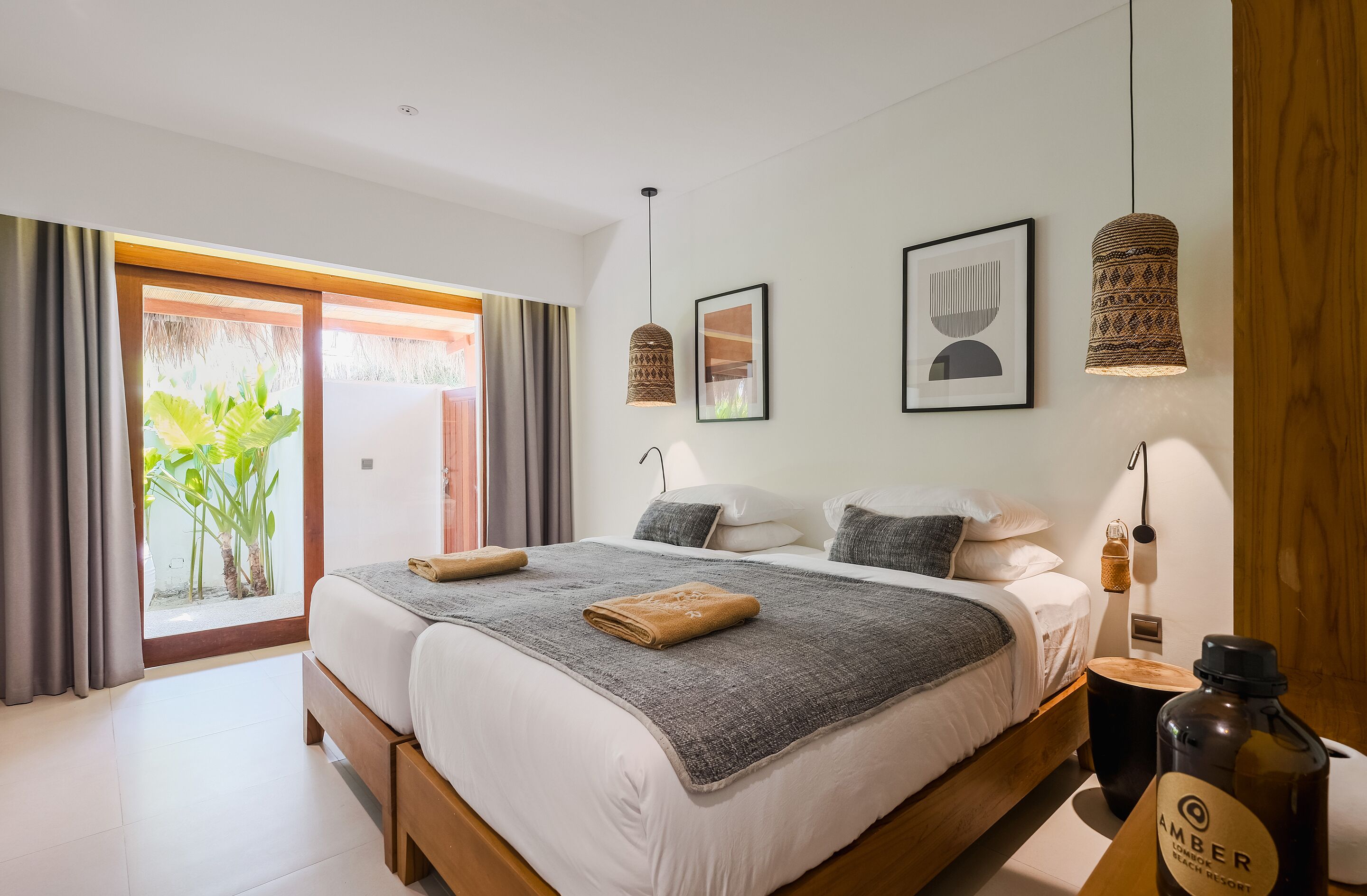 Une chambre à coucher moderne avec un grand lit, deux tables de chevet, une petite table et une lampe suspendue.