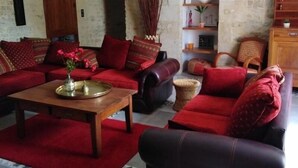 A cozy living room with a red sofa set, a wooden coffee table, and a fireplace.