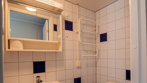 A small bathroom with a white sink, a mirror, and a white toilet.