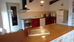 A kitchen with red cabinets, a wooden countertop, a stainless steel oven, and a white refrigerator. - Charming Cottage with Private Pool, Sauna, and Garden in Saint-Juire-Champgillon (Saint-Juire-Champgillon)