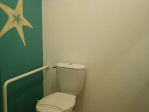 A bathroom with a toilet, a starfish decoration on the wall, and a white handrail. - Cozy Farmhouse with Private Pond, Terrace, and Ultralight Airstrip Nearby (Vairé)