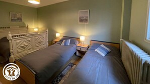 A hotel room with two beds, a radiator, and two bedside tables with lamps. - Charming Renovated House with Private Pool in Saint-Christophe-du-Ligneron (Saint-Christophe-du-Ligneron)