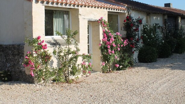 A traditional building with a tiled roof, a chimney, and a gravel driveway. - Charming Renovated House with Private Pool in Saint-Christophe-du-Ligneron (Saint-Christophe-du-Ligneron)