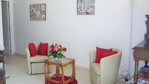 A living room with two sofas, a glass coffee table, and a floor lamp. - Cozy Traditional Cottage with Private Garden, Near La Garnache (La Garnache)