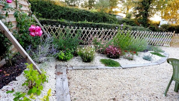 A garden with a wooden fence, various plants, and a gravel path. - Cozy Traditional Cottage with Private Garden, Near La Garnache (La Garnache)