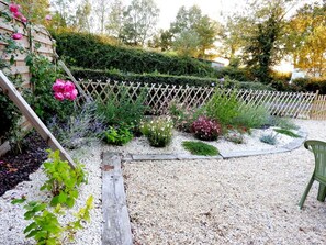 A garden with a wooden fence, various plants, and a gravel path. - Cozy Traditional Cottage with Private Garden, Near La Garnache (La Garnache)