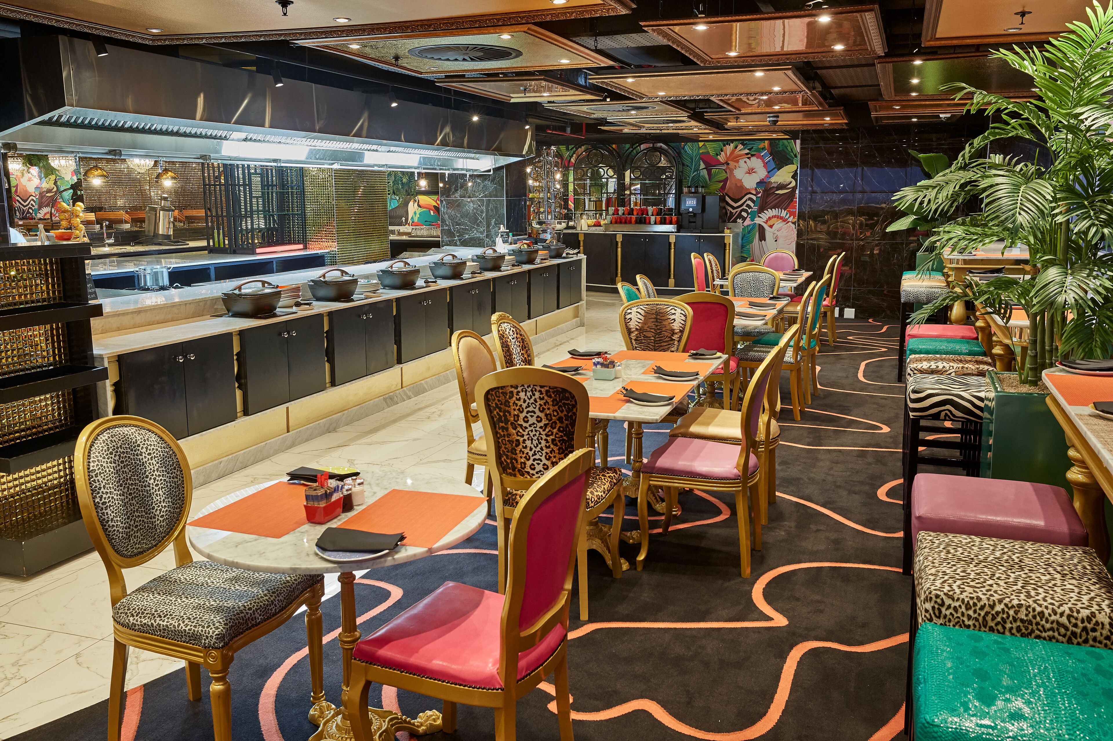 Un restaurant doté d’un long comptoir, de plusieurs tables et de chaises.
