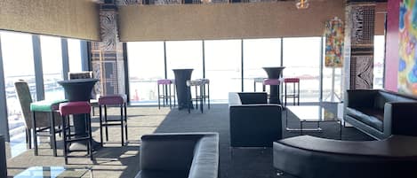 A modern lounge area with leather sofas, a glass coffee table, and patterned walls.