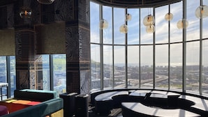 A modern interior with a curved seating area, large windows offering a city view, and patterned walls. - Hotel Sky Cape Town (Cape Town)