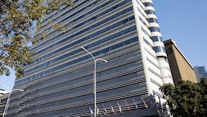 A modern high-rise building with a glass facade, a prominent entrance, and a clear blue sky in the background. - Hotel Sky Cape Town (Cape Town)
