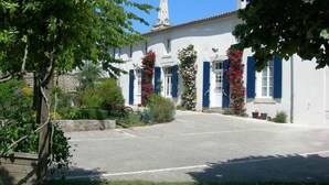 A white building with blue shutters and a tower. - Charming Riverside House with Canoes, Garden, and Nearby Market in Marais Poitevin (Damvix)