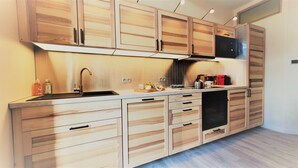 Una cucina moderna con mobili in legno, un lavello in acciaio inossidabile e un forno integrato.
