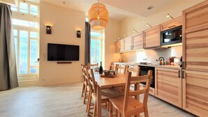 Una cucina moderna con mobili in legno, un forno a microonde e un'area pranzo con tavolo e sedie.