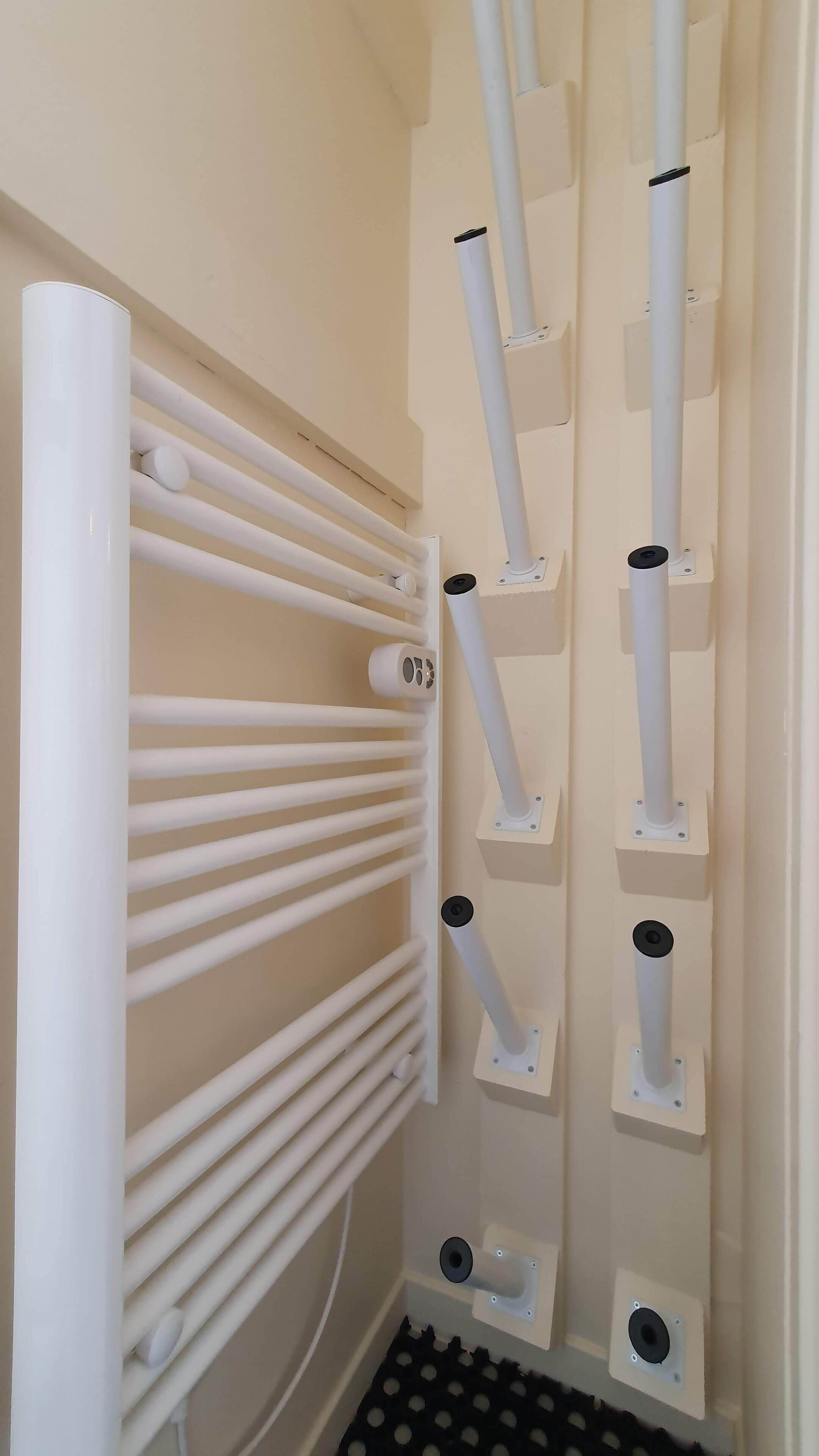 A white radiator with multiple pipes and a control panel.