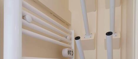 A white radiator with multiple pipes and a control panel.