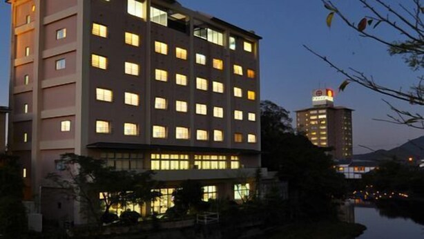 Un hotel de varios pisos con un diseño arquitectónico moderno, situado cerca de una masa de agua.