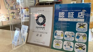 Un panneau avec un code QR, un certificat encadré et une affiche bleue contenant des informations et des icônes.