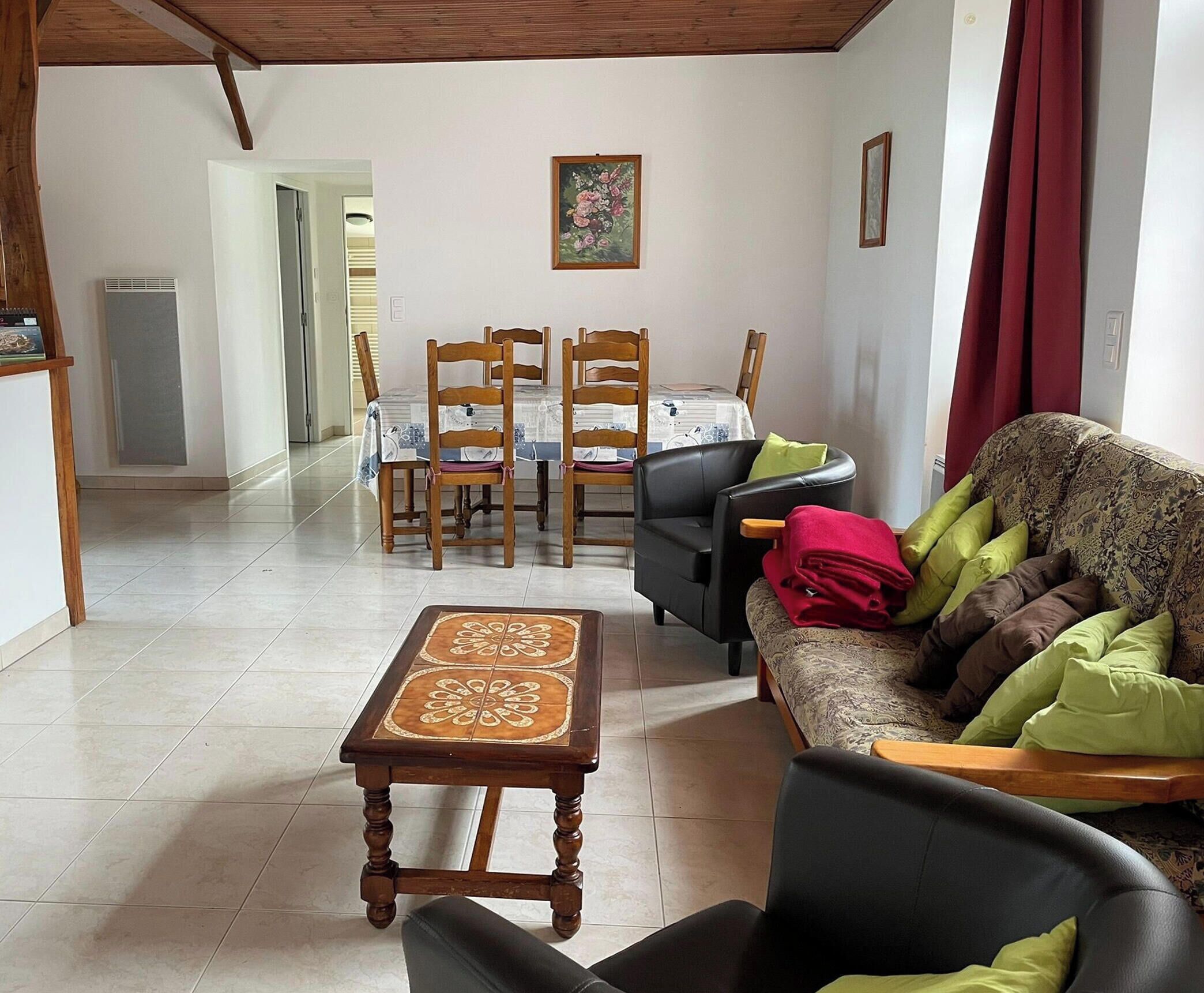 A living room with a sofa, a dining table with chairs, and a coffee table.