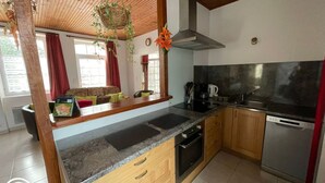 Una cocina con armarios de madera, encimera negra, estufa y lavavajillas.