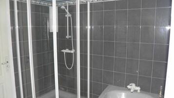 Ein Badezimmer mit Duschkabine, Badewanne und gefliesten Wänden.