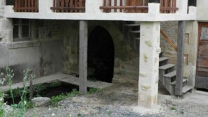 A two-story building with a balcony, a staircase, and a small garden area. - Charming Watermill Gîte: 6BR, Fireplace, Private Garden, Pond, Terrace, WiFi, Linens Included (Foussais-Payré)