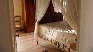 A bedroom with a four-poster bed, wooden headboard, and a canopy. - Charming Watermill Gîte: 6BR, Fireplace, Private Garden, Pond, Terrace, WiFi, Linens Included (Foussais-Payré)